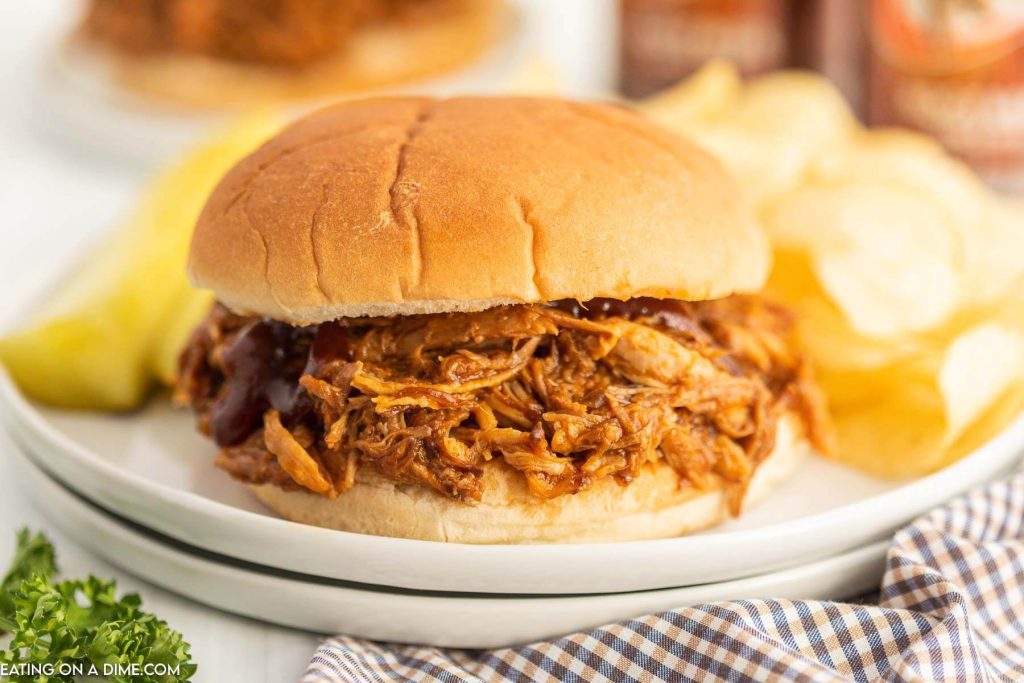 BBQ Pork Sandwich on a plate with chips on the side