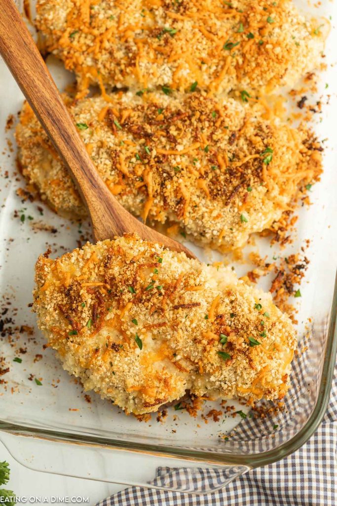 Baked Ranch Chicken in a baking dish with a serving on a wooden spoon
