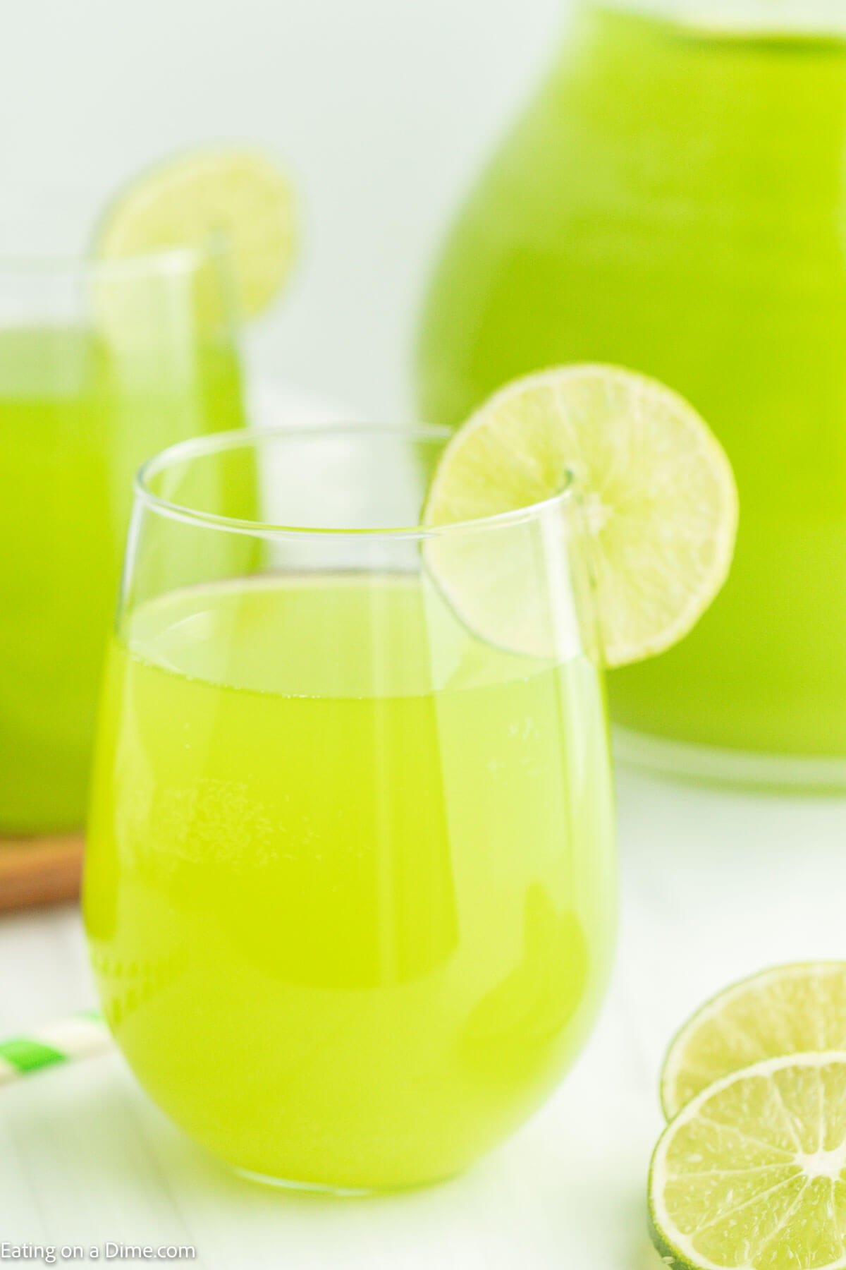Green Punch in a glass with a lime wedge on the side of the glass