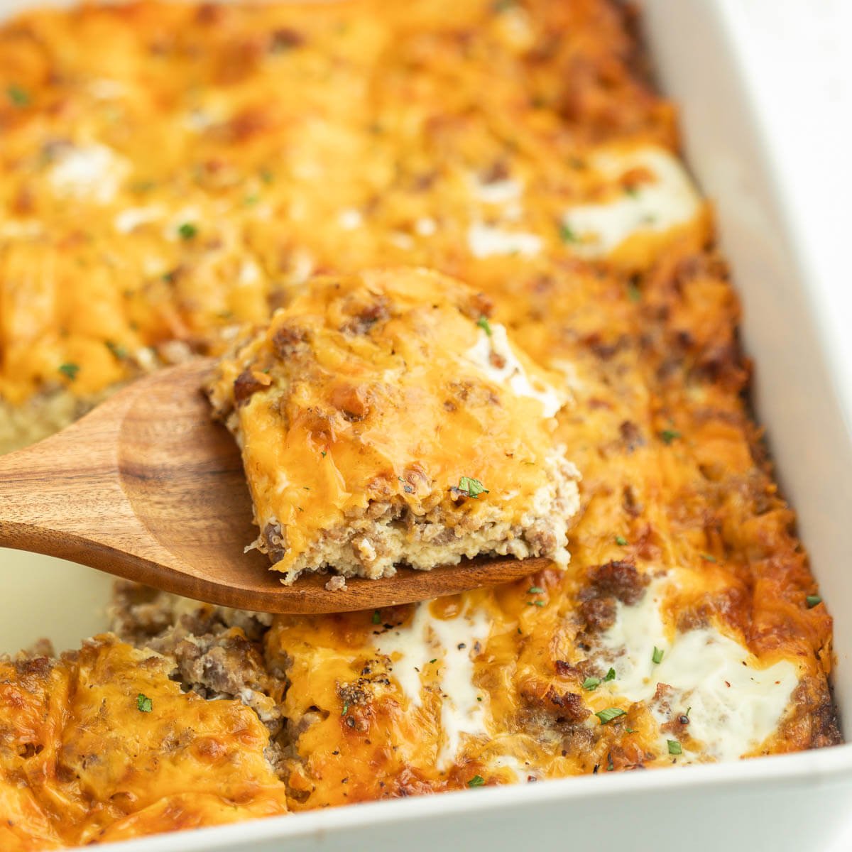 Breakfast Casserole in a baking dish with a serving on a wooden spatula