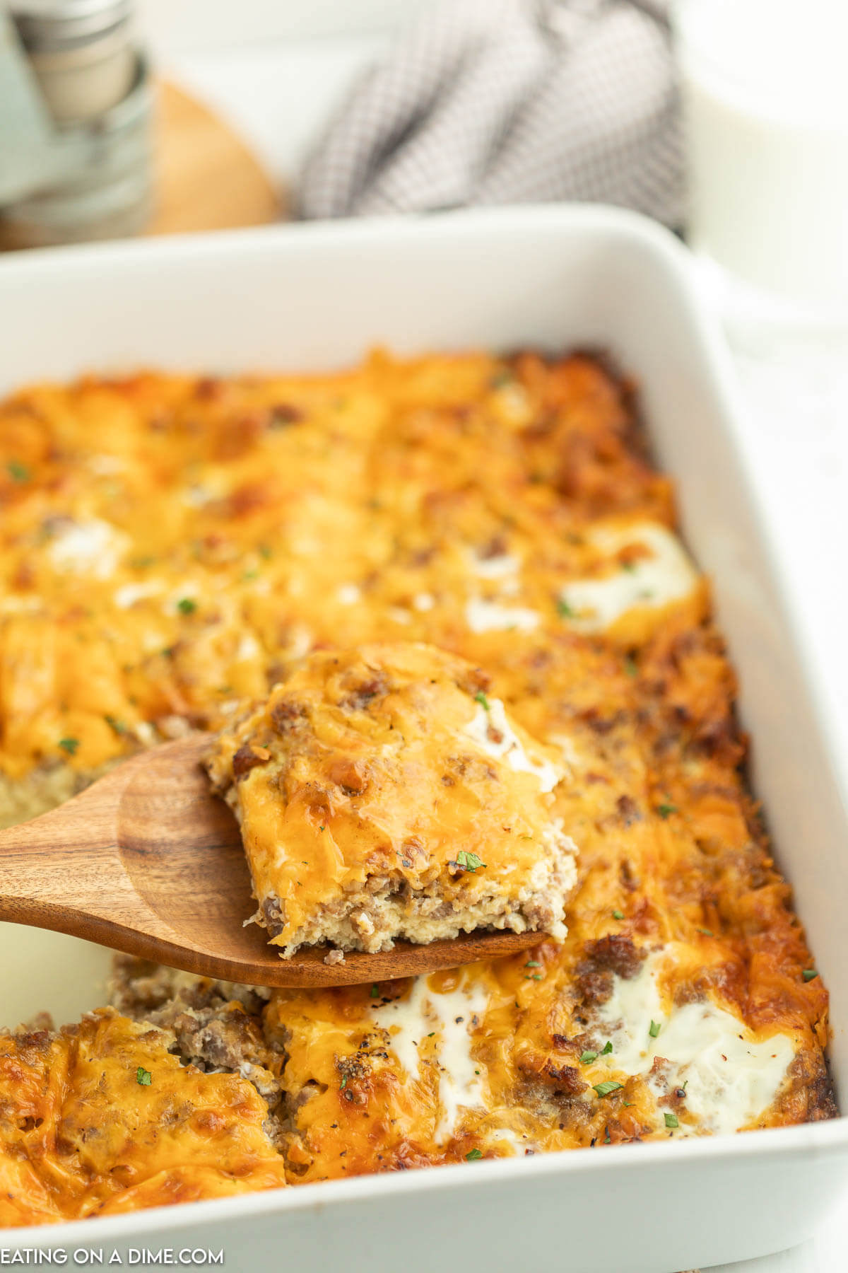 Breakfast Casserole in a baking dish with a serving on a wooden spatula