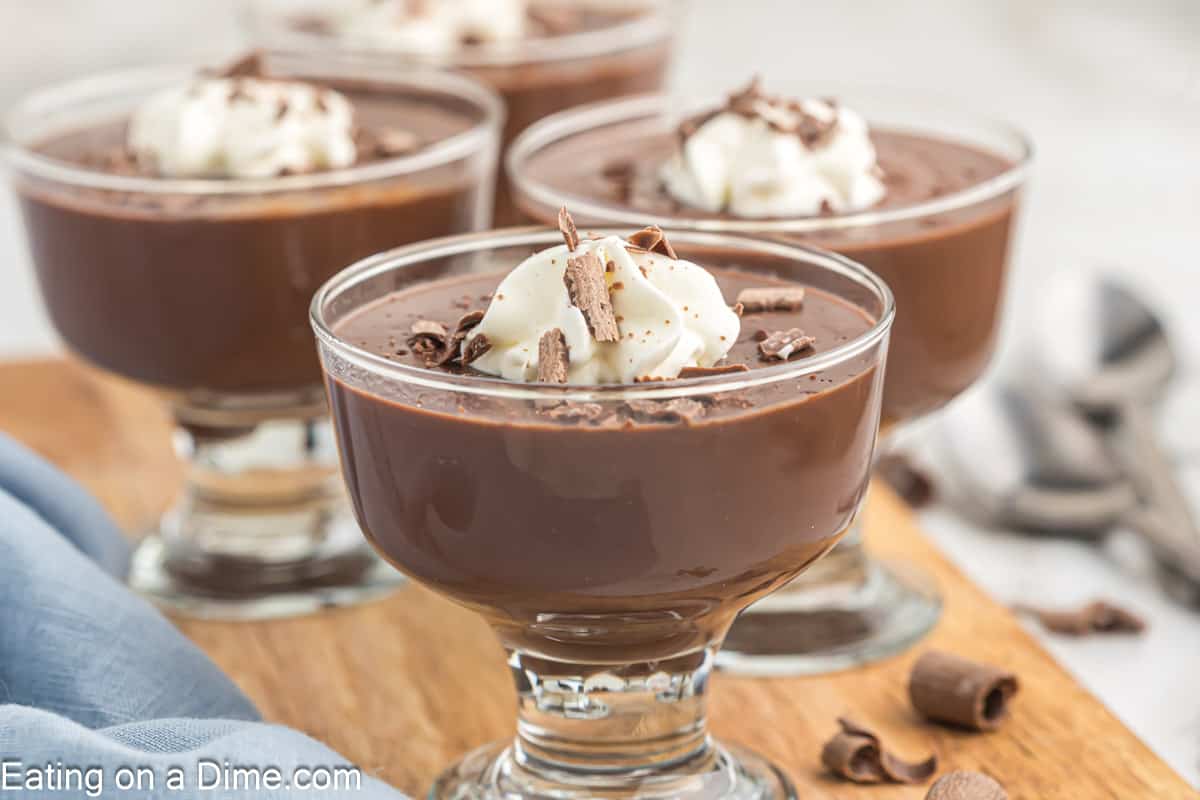 Chocolate Pudding in individual glassed topped with whipped cream and shaved chocolate