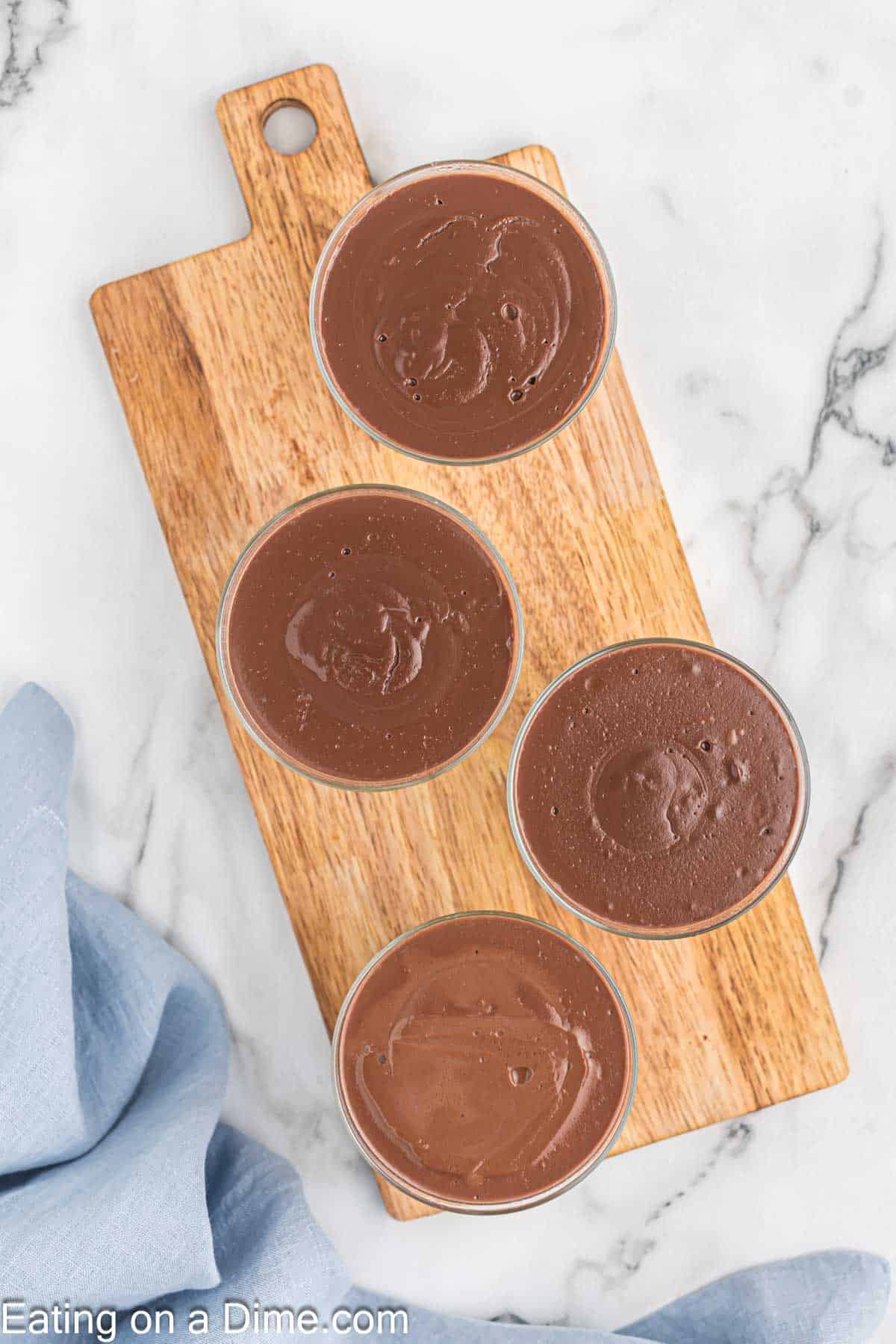 Chocolate Pudding in individual glasses on a cutting board