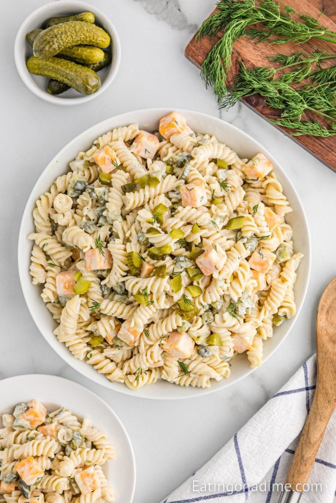 Dill Pickle Pasta Salad in a bowl with a wooden spoon