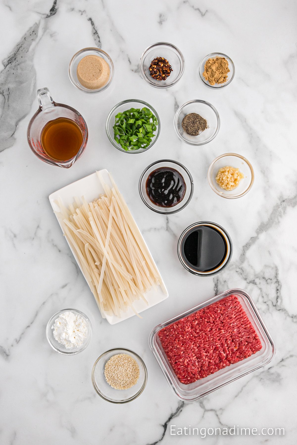 Ingredients needed - ground beef, ground ginger, garlic, brown sugar, beef broth, soy sauce, hoisin sauce, pepper, red pepper flakes, rice noodles, cornstarch, green onions, and sesame seeds