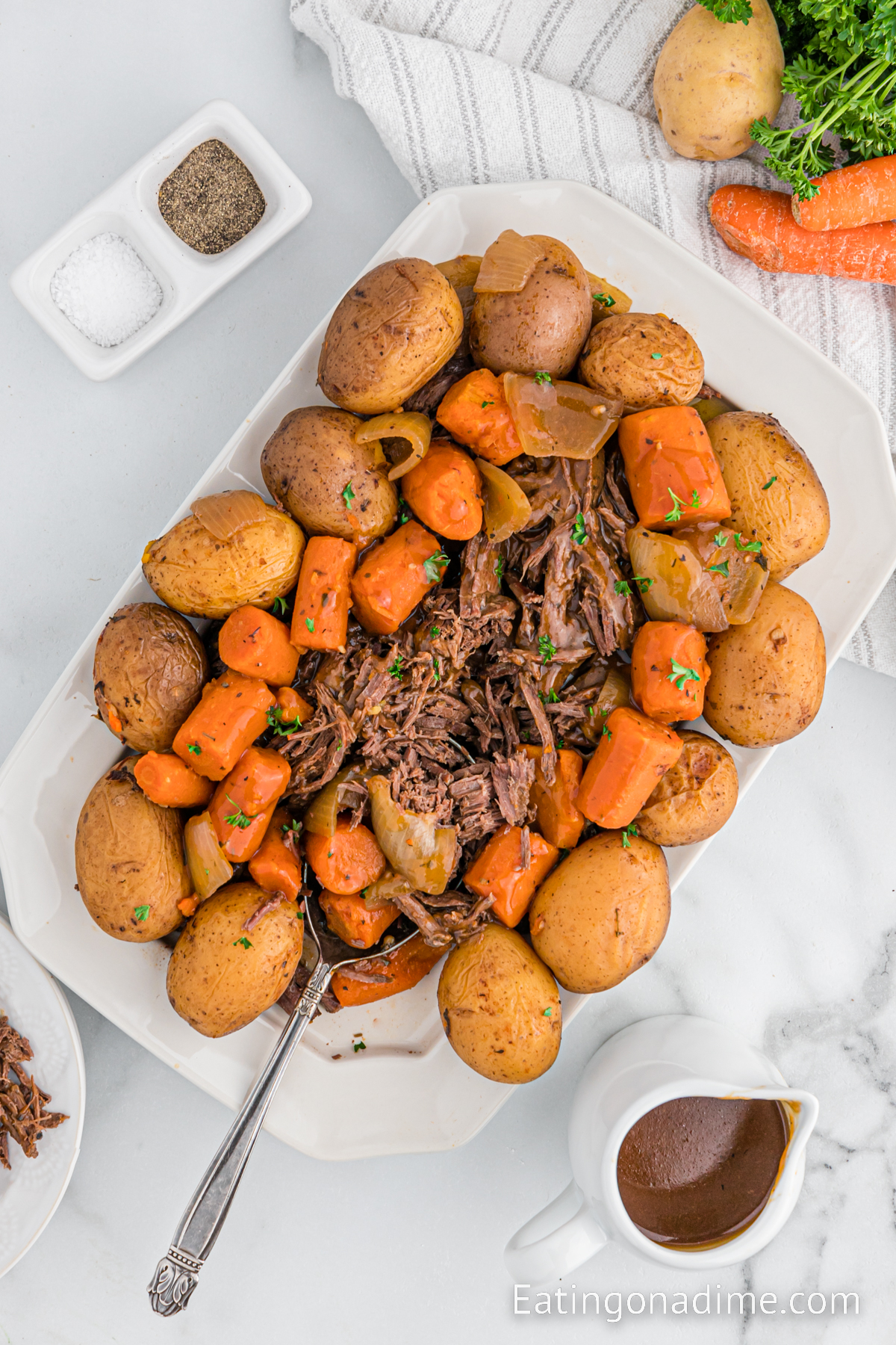 Venison Roast potatoes and carrots on a platter with a spoon