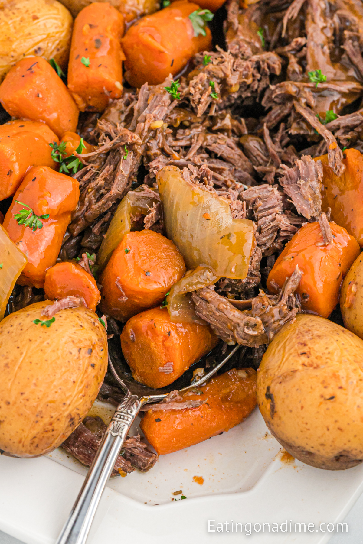 Venison Roast potatoes and carrots on a platter with a spoon