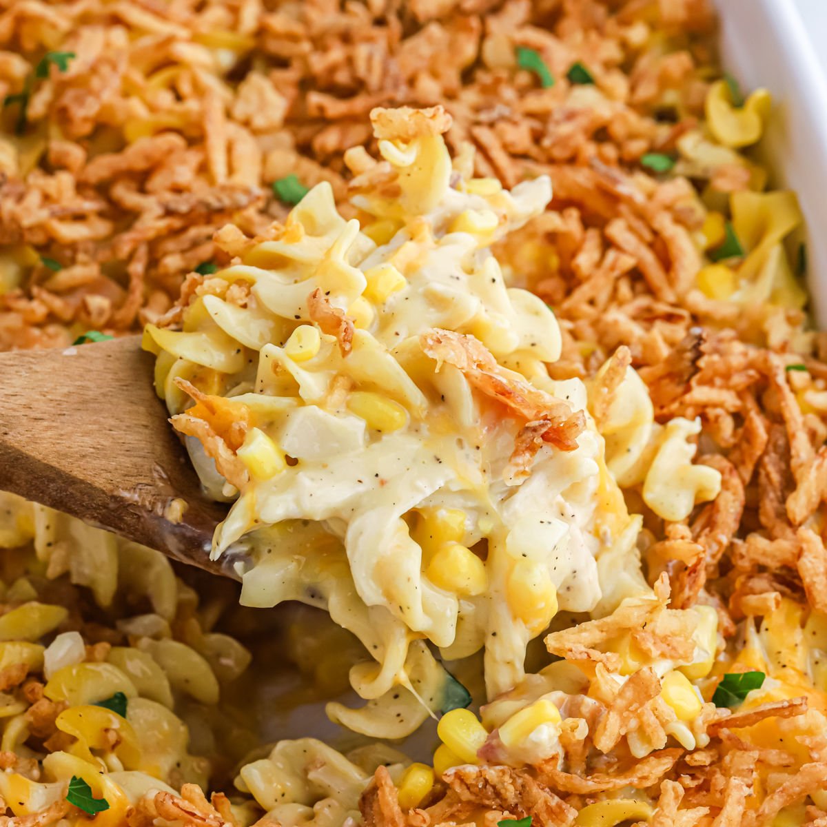 Ultimate Chicken Casserole in a baking dish with a wooden spoon