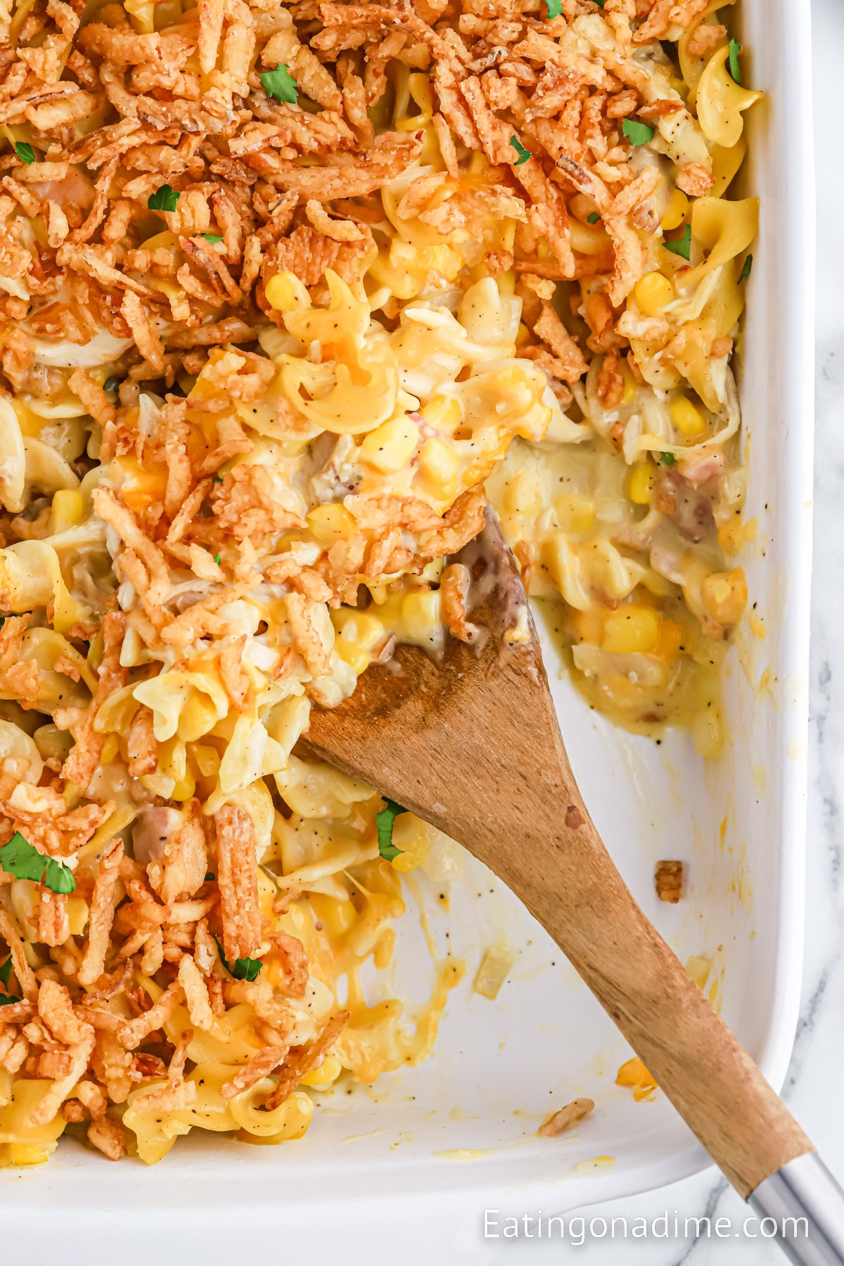 Ultimate Chicken Casserole in a baking dish with a wooden spoon