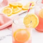 Pink Lemon in a clear glass garnished with a lemon slice.
