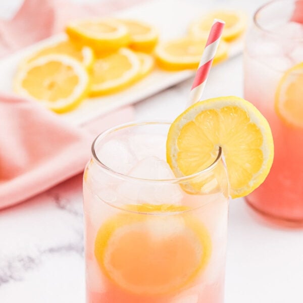 Pink Lemon in a clear glass garnished with a lemon slice.