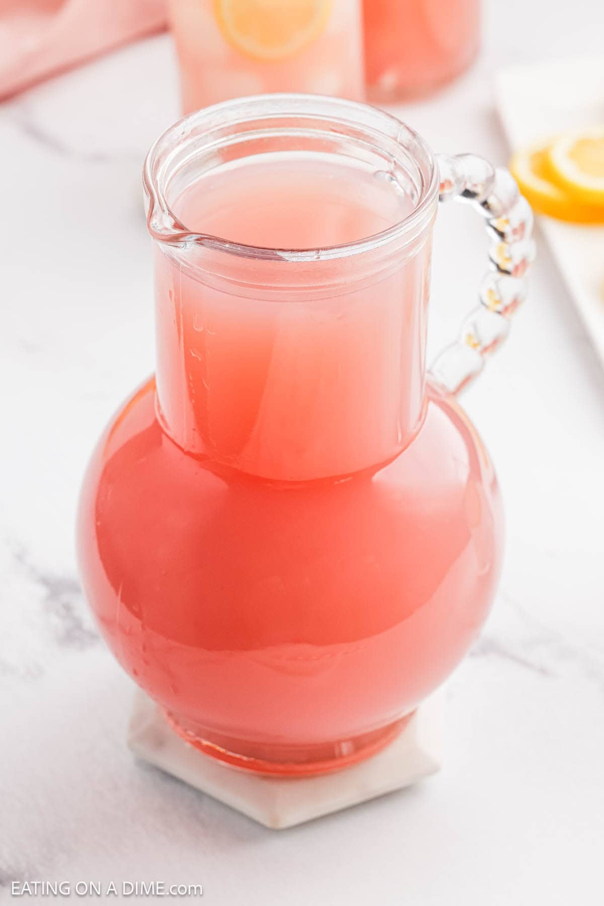 Pink drink in a large clear glass pitcher.