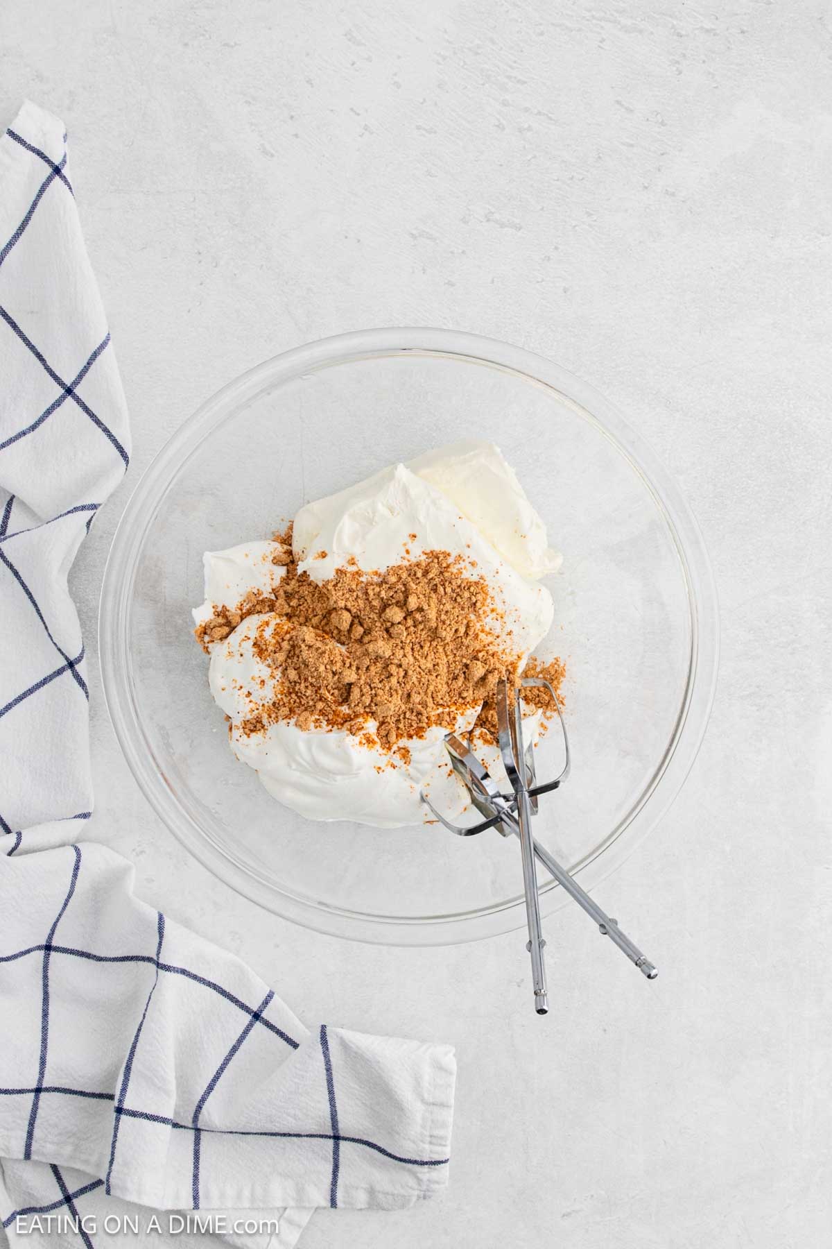 Cream cheese and taco seasoning in a bowl with hand mixer