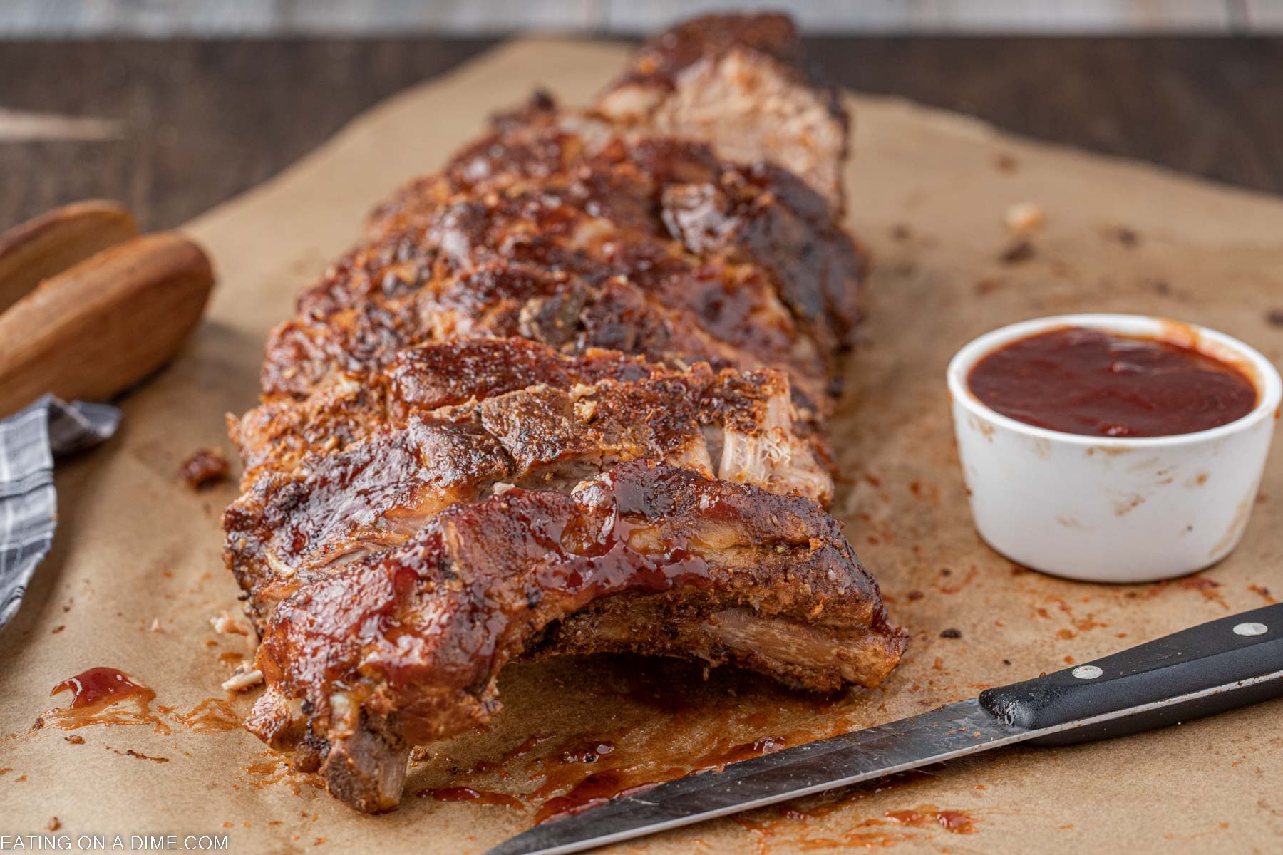 Baby back ribs slice on a platter with a side of BBQ Sauce