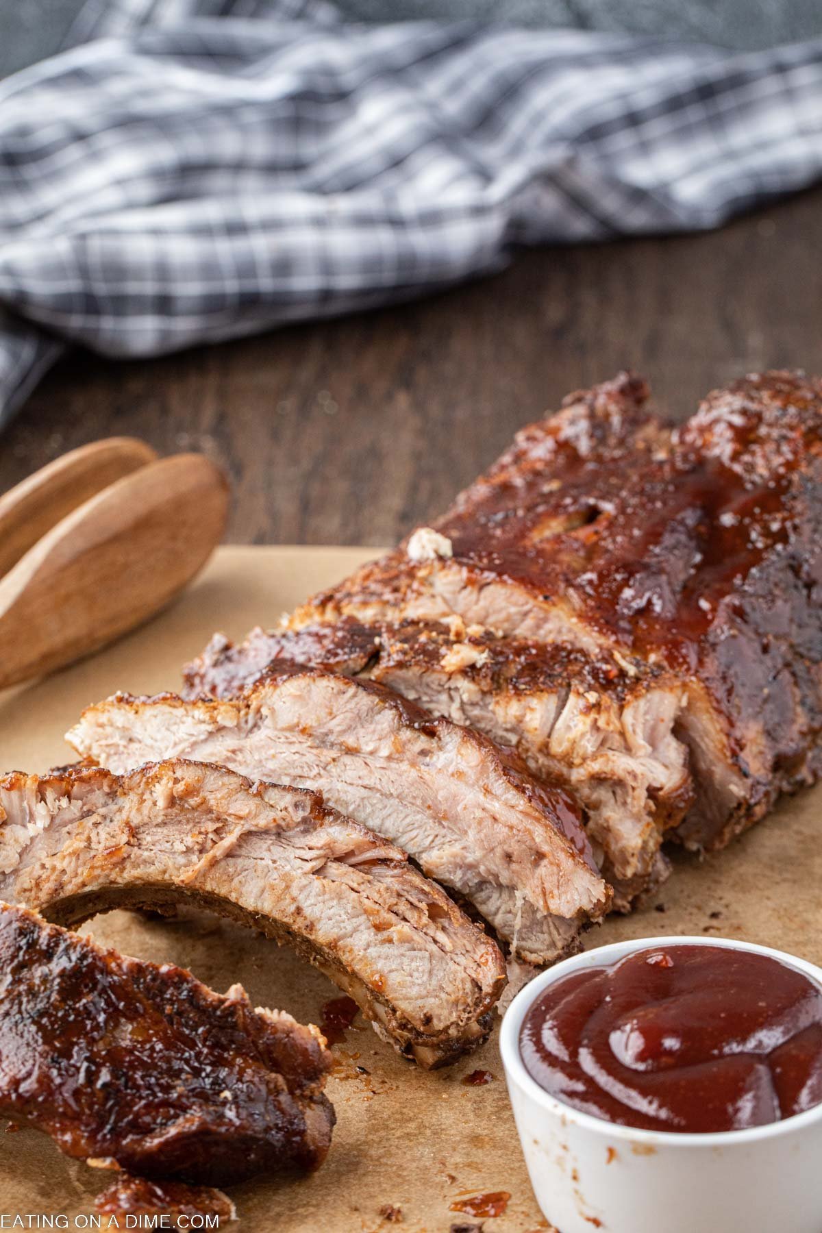 Baby back ribs slice on a platter with a side of BBQ Sauce