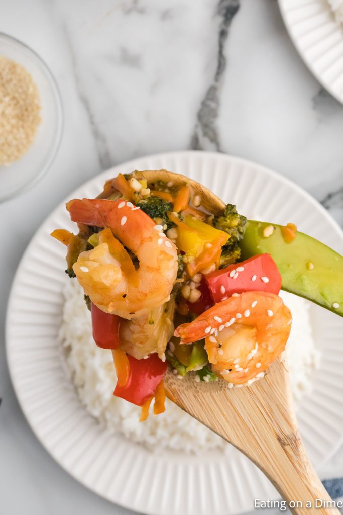 Shrimp Stir Fry with white rice and a serving on a wooden spoon