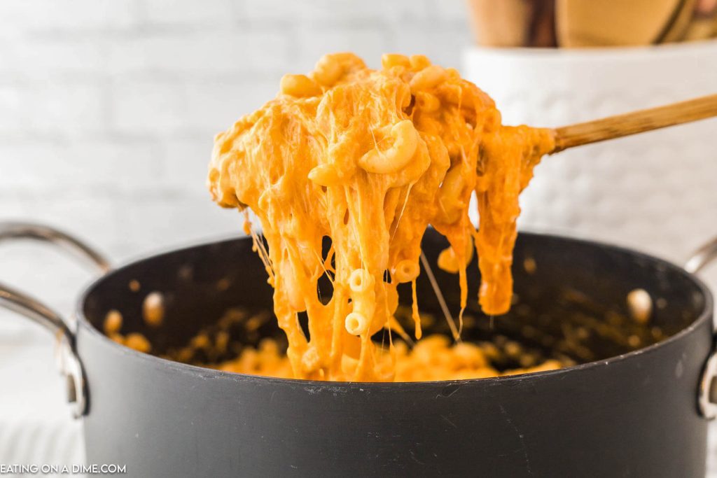 Buffalo Chicken Mac and Cheese in a large pot with a serving on a wooden spoon