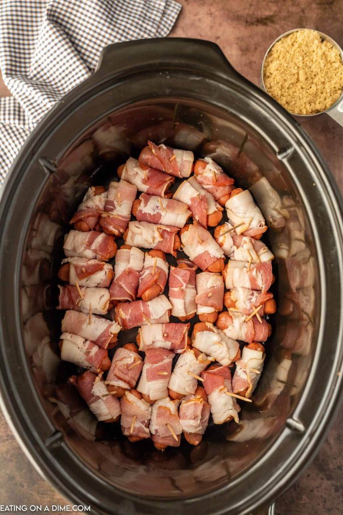 Uncooked Bacon wrapped lil smokies in the slow cooker