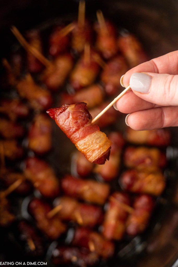 Bacon wrapped lil smokies stacked in the slow cooker