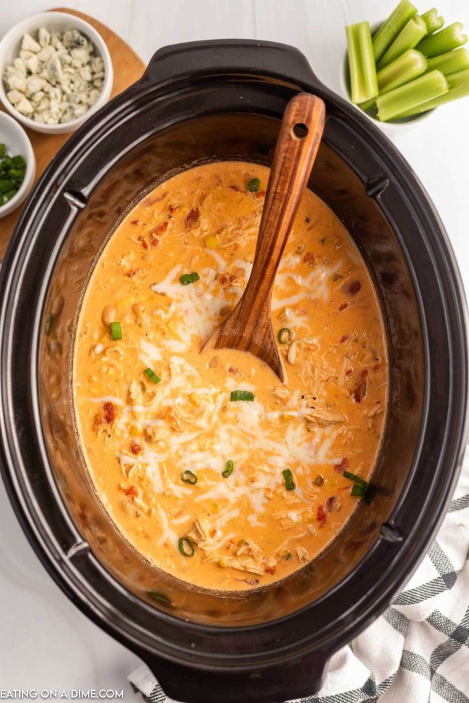 Buffalo Chicken Chili in the slow cooker with a wooden spoon