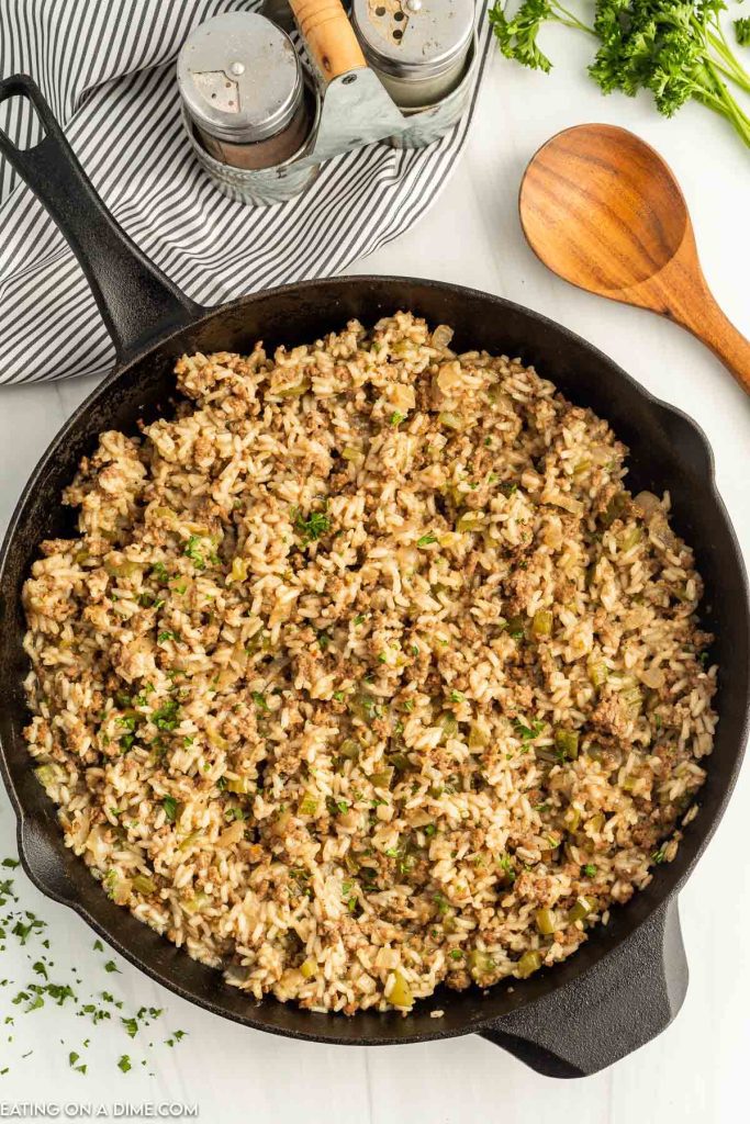 Dirty Rice in a skillet with a wooden spoon