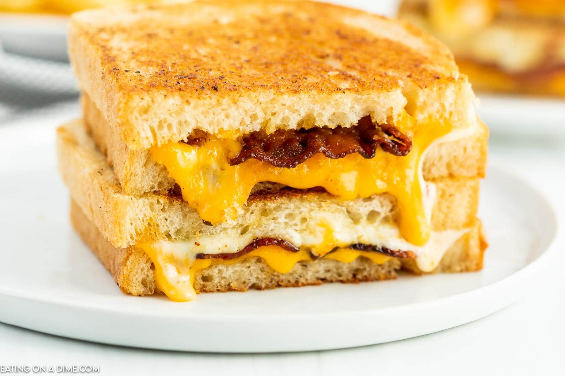 Bacon Grilled Cheese cut into half on a plate