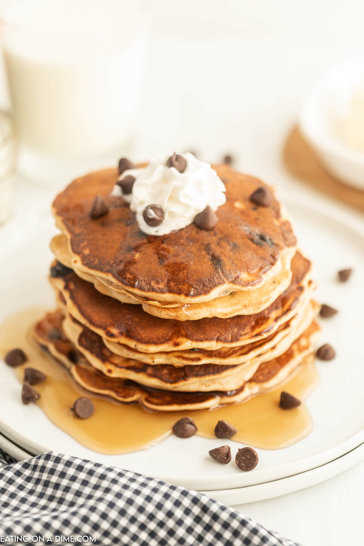 Chocolate Chip Pancakes stacked with syrup, whipped cream and chocolate chips