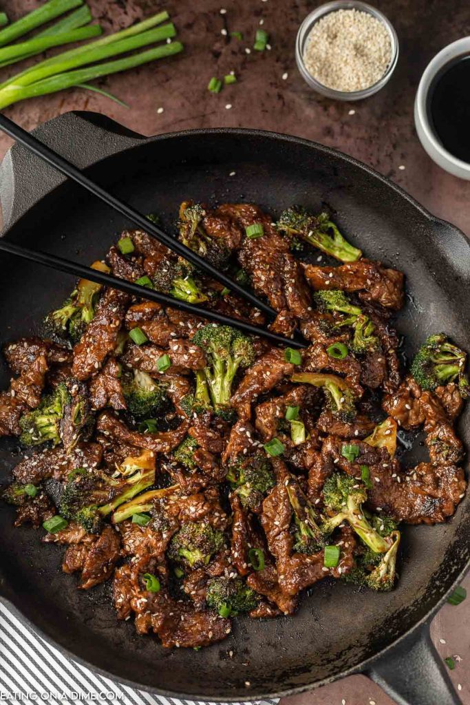 Beef and Broccoli in a skillet with chopsticks