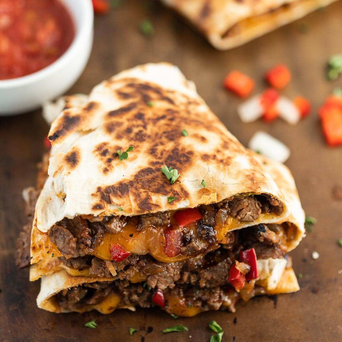 Steak Fajita Quesadillas sliced and stacked with a side of salsa