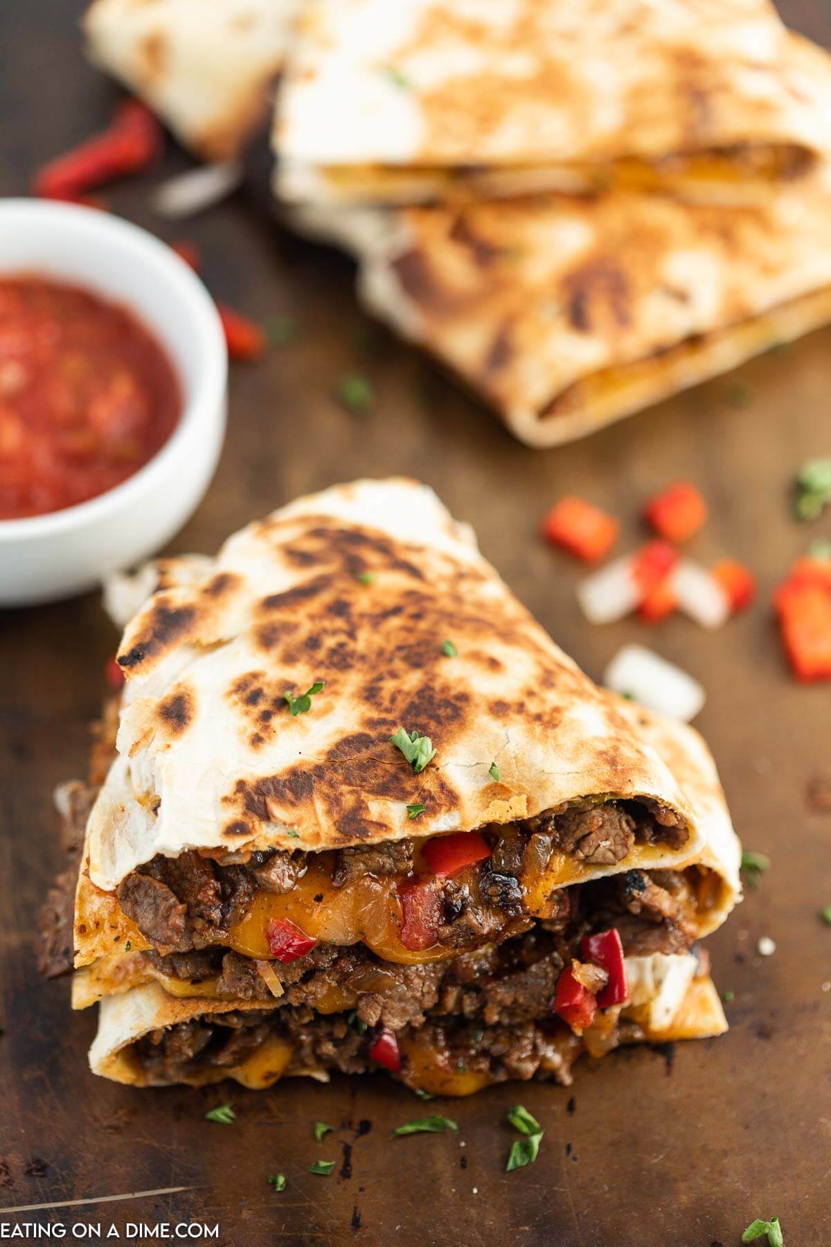 Steak Fajita Quesadillas sliced and stacked with a side of salsa