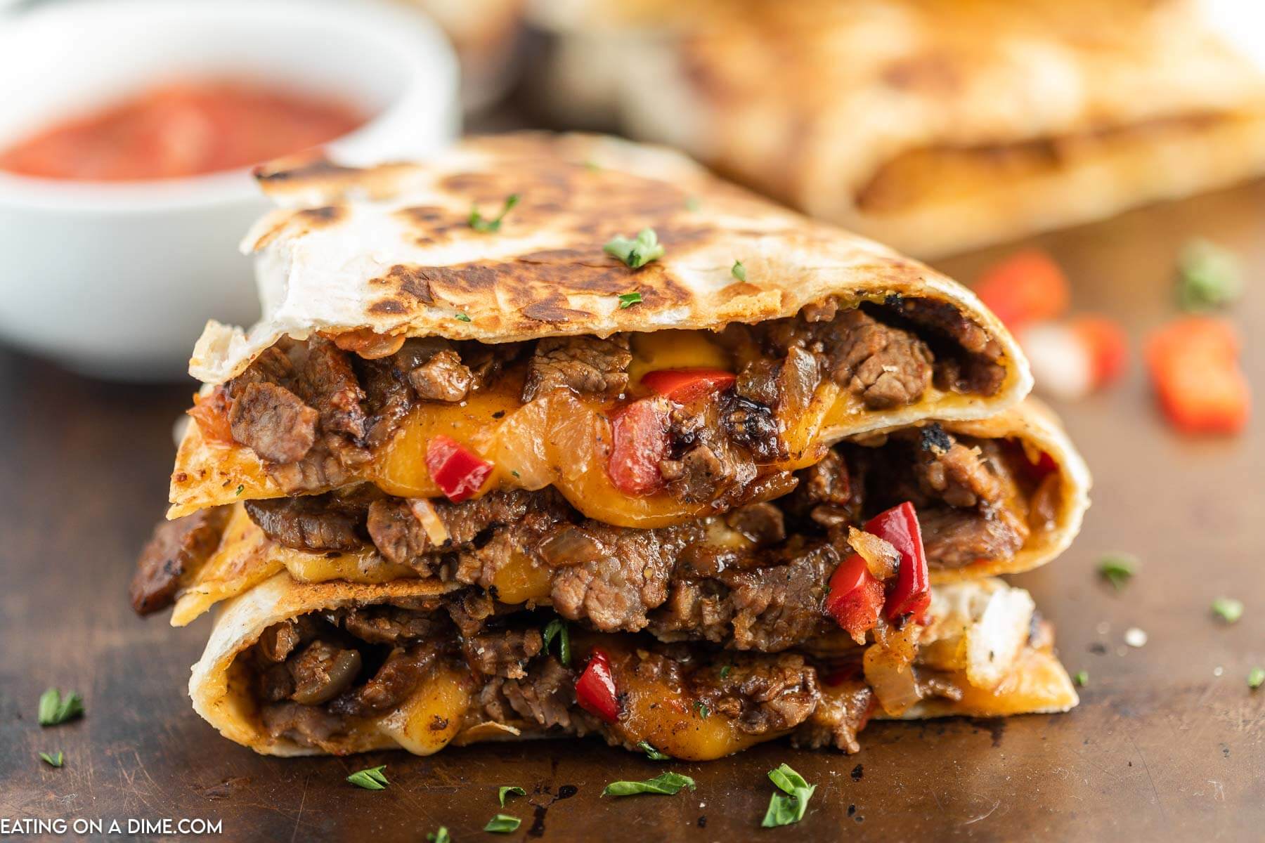 Steak Fajita Quesadillas sliced and stacked with a side of salsa