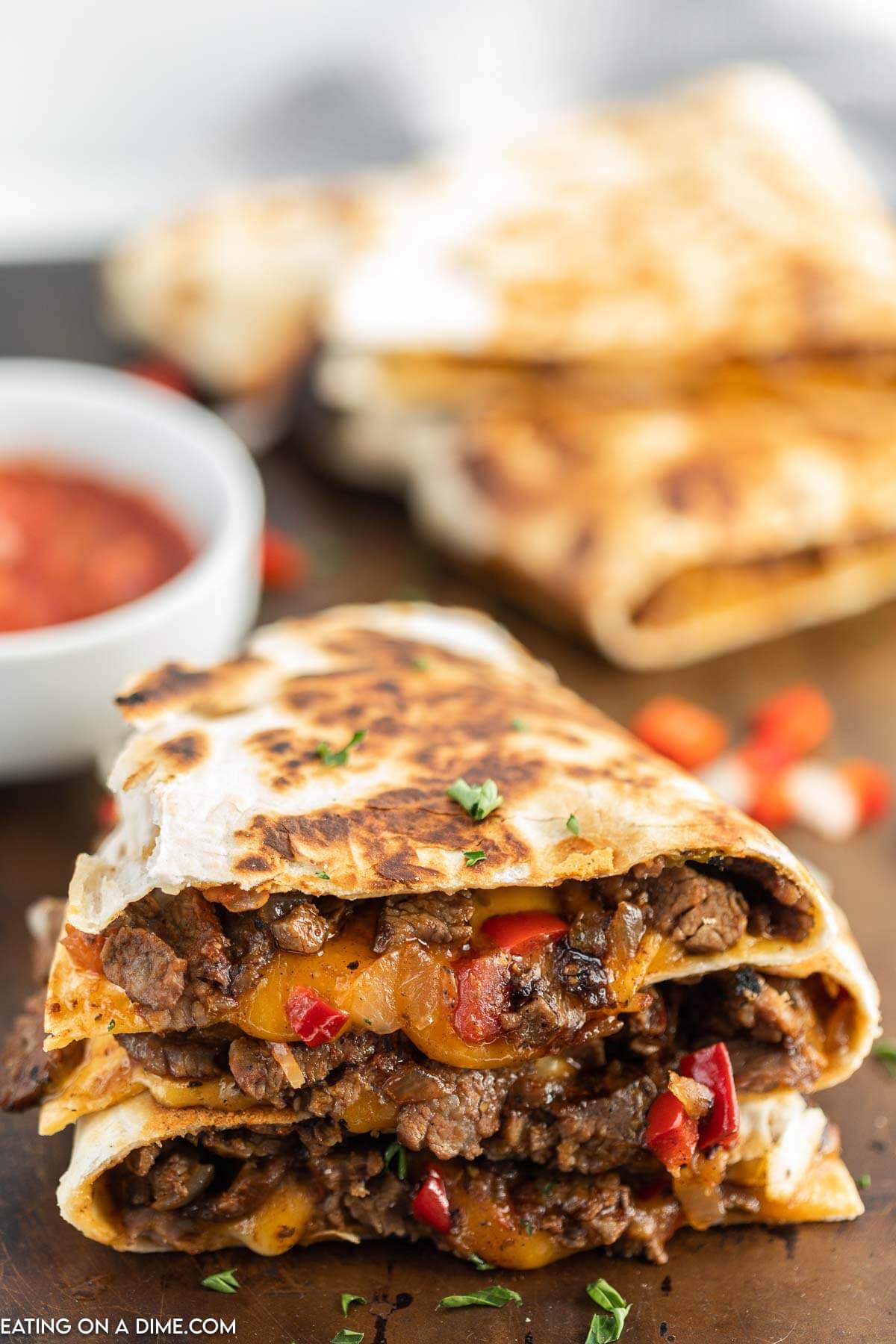 Steak Fajita Quesadillas sliced and stacked with a side of salsa