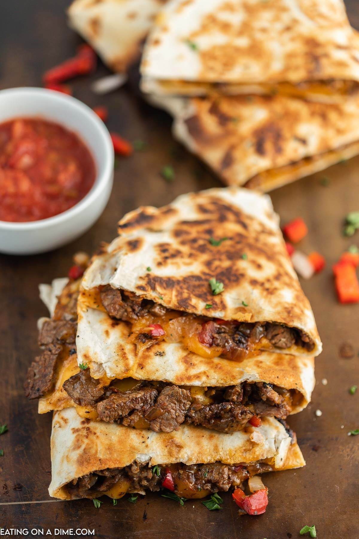 Steak Fajita Quesadillas sliced and stacked with a side of salsa