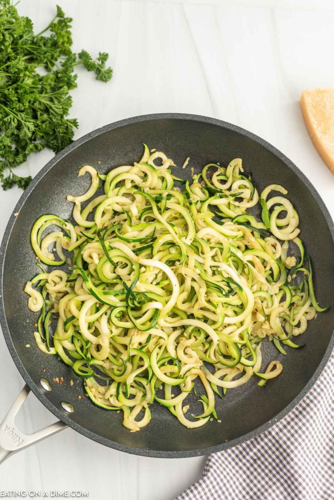Zucchini Noodles cooking in a large skillet