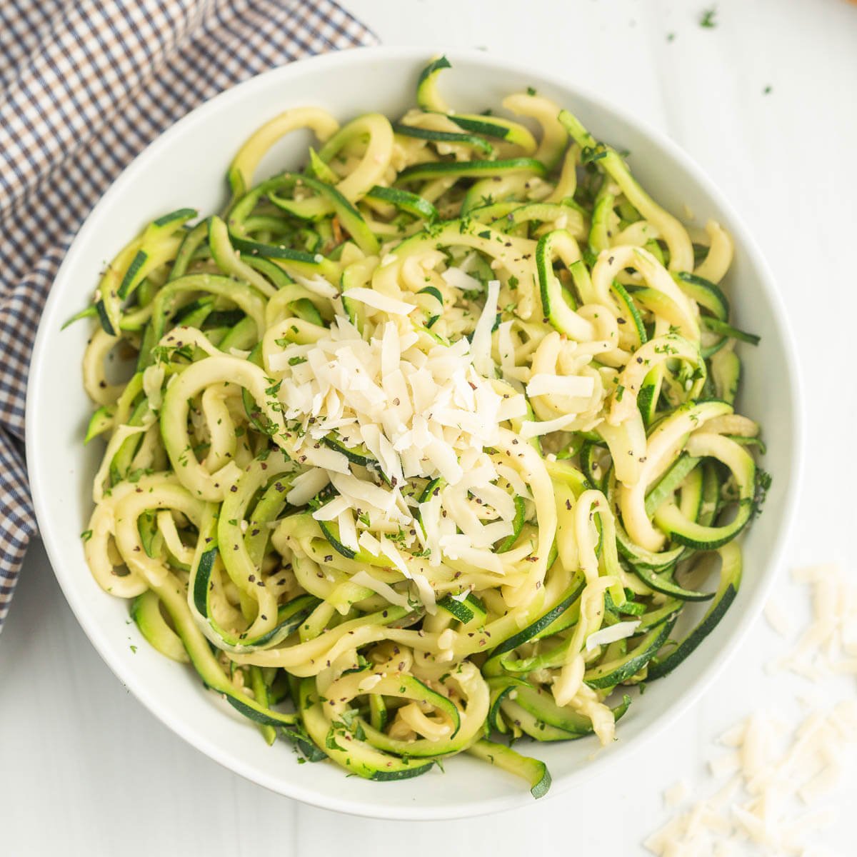 Zucchini Noodles topped with mozzarella cheese in a white bowl