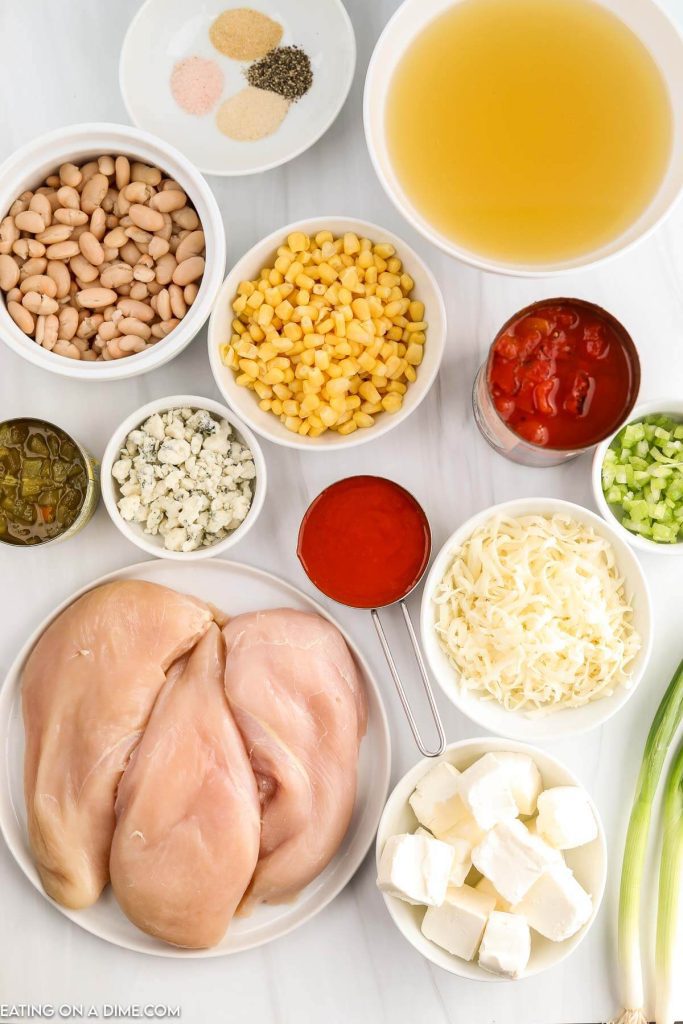 Ingredients needed - chicken breast, chicken broth, diced tomatoes, green chiles, buffalo sauce, corn, celery, onion powder, pepper, salt, cream cheese, monterey jack cheese, blue cheese crumbles, green onions