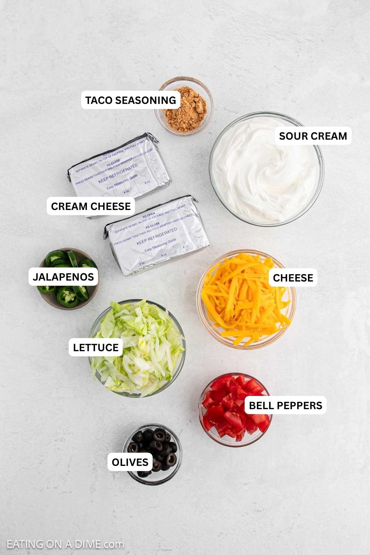 Ingredients for recipe: olives, bell peppers, lettuce, cheese, jalapenos, cream cheese, sour cream and taco seasoning.