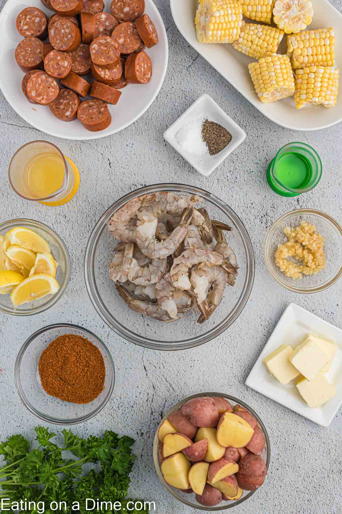 Ingredients for shrimp boil - Shrimp, sausage, corn, red potatoes, olive oil, garlic, old bay seasoning, salt, pepper, lemon, butter, parsley