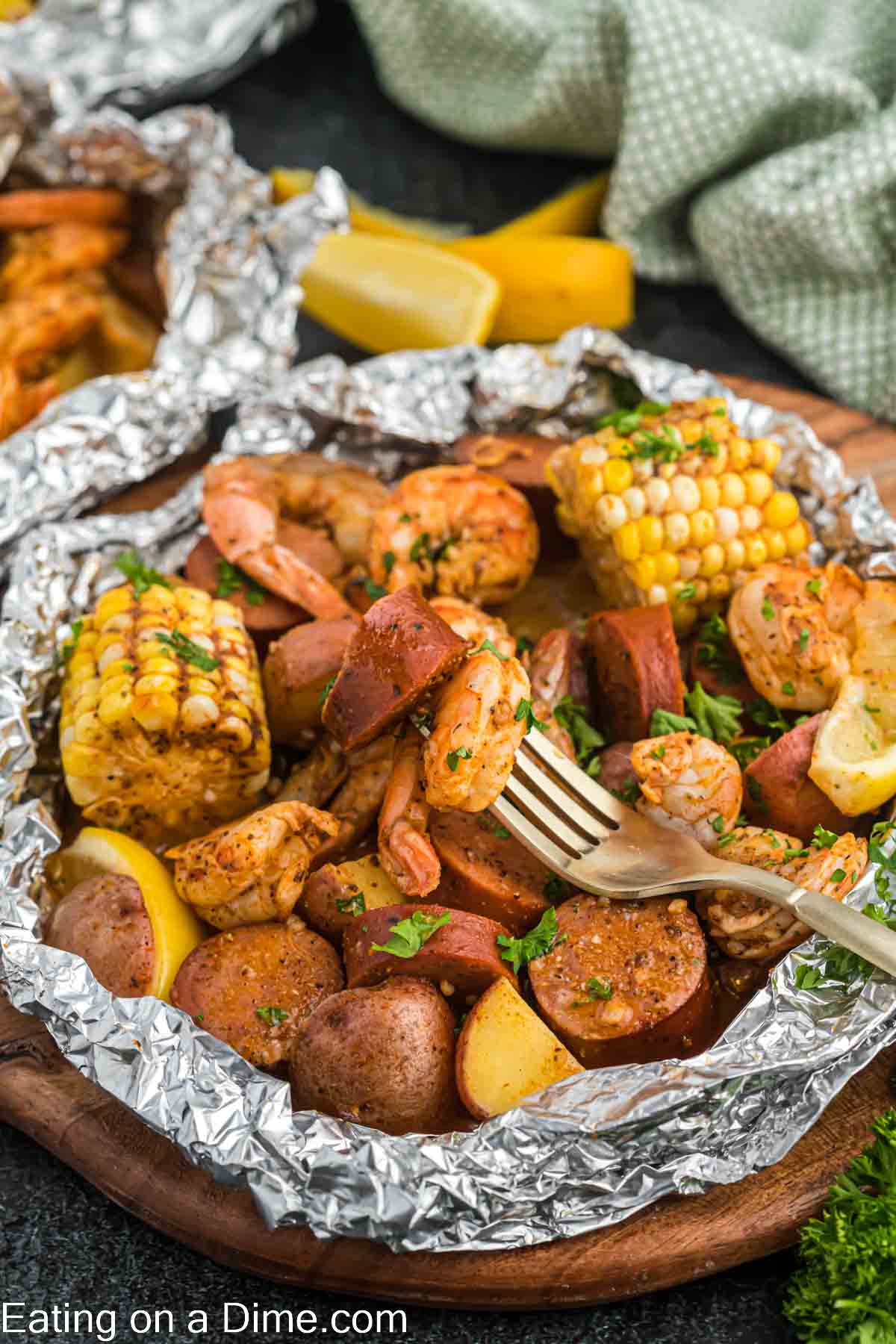 Shrimp boil foil pack ready to serve with sausage and shrimp on a fork