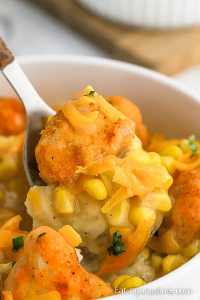 KFC Bowls loaded with chicken, cheese, corn and mashed potatoes with a bit on a fork