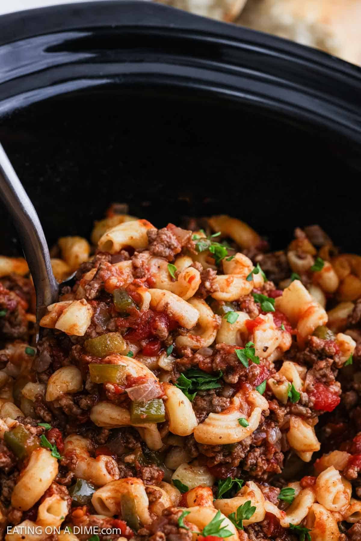 A serving of the macaroni noodles and ground beef mixture on a ladle.