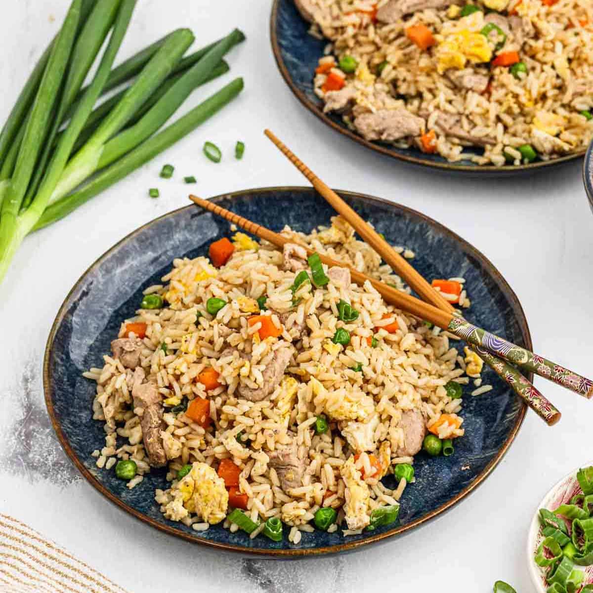 Pork Fried Rice on a plate with chopsticks on the side.