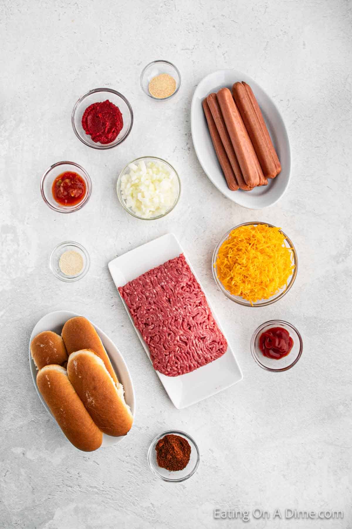 Hot dog chili ingredients - ground beef, ketchup, hot dogs, salsa, onion powder, tomato paste, garlic powder, chili powder, hot dog buns, diced onions, cheese, mustard