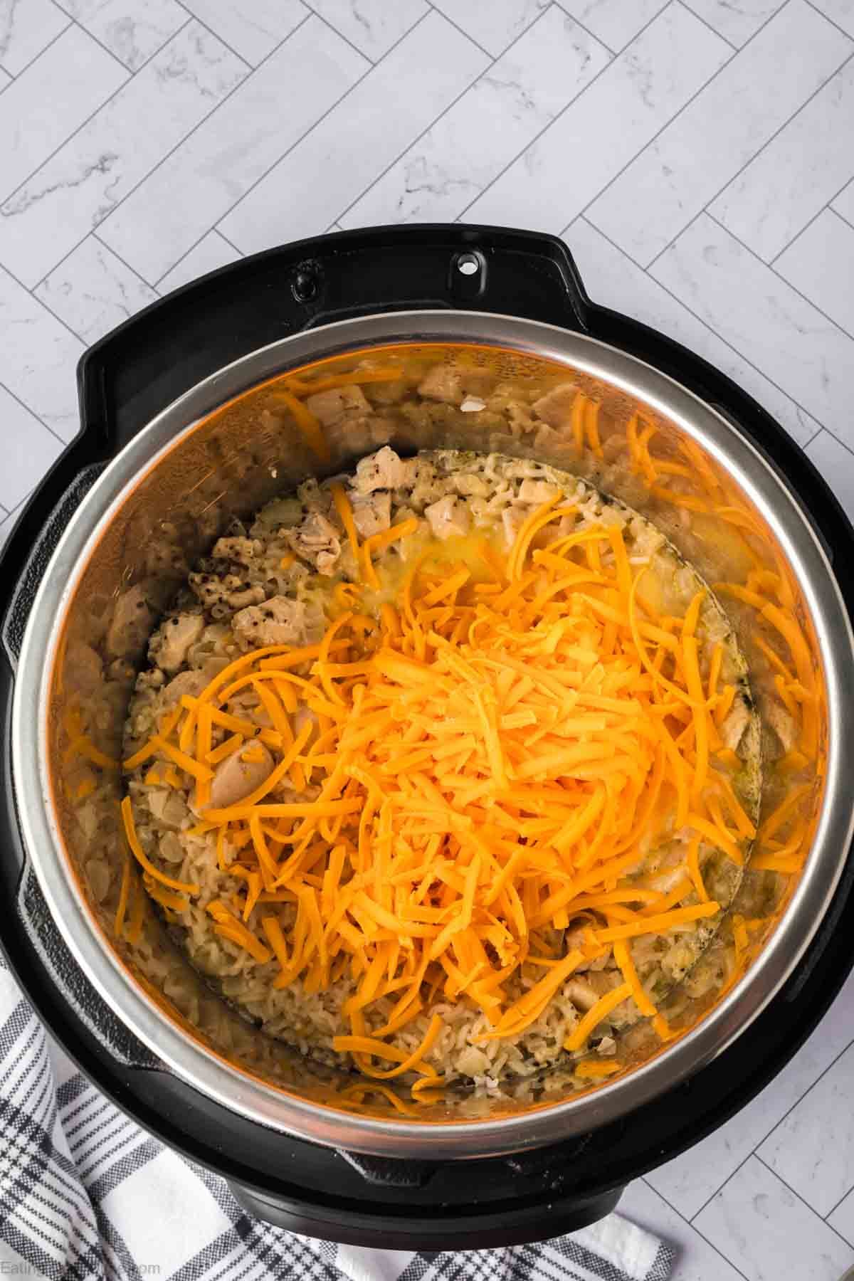Shredded cheese over the cooked chicken and rice in the instant pot