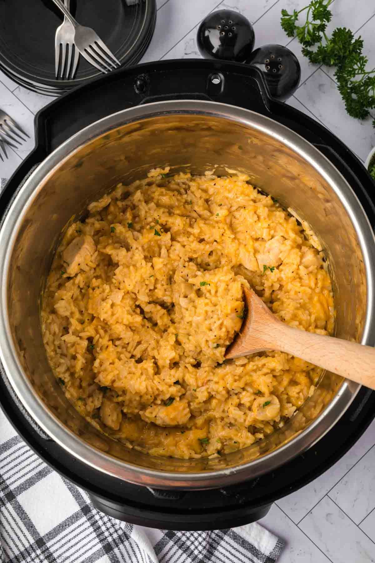 Cheesy, chicken and rice in the instant pot with the wooden spoon