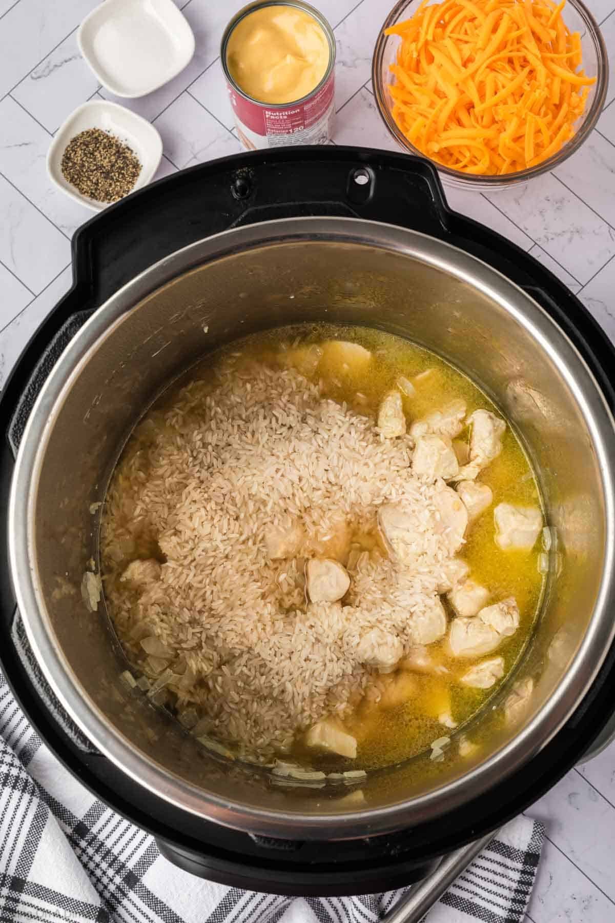 Uncooked rice topped with dice chicken and cream of chicken soup in the instant pot