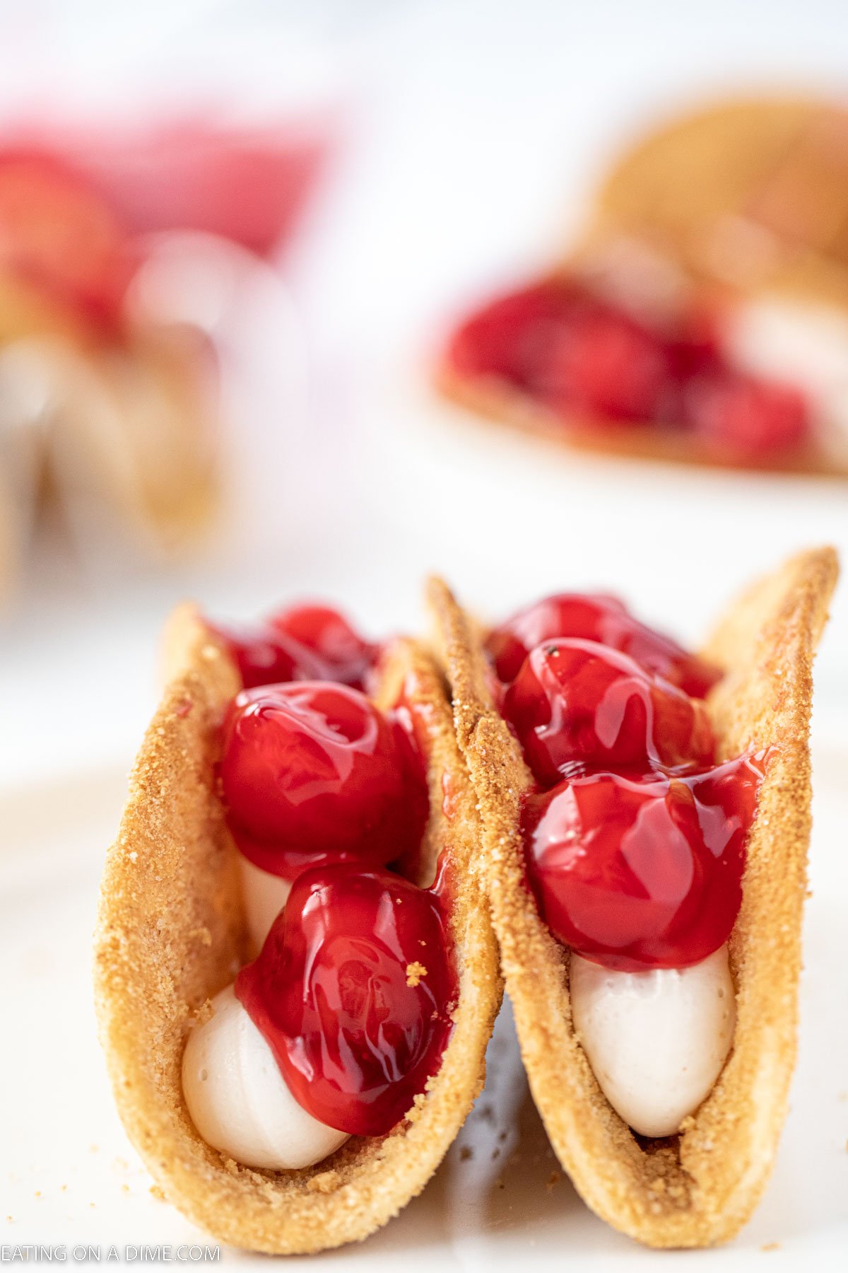 Cheesecake Tacos close together topped with cherry pie filling