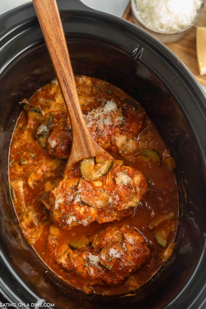 Chicken and Zucchini in the slow cooker with a wooden spoon