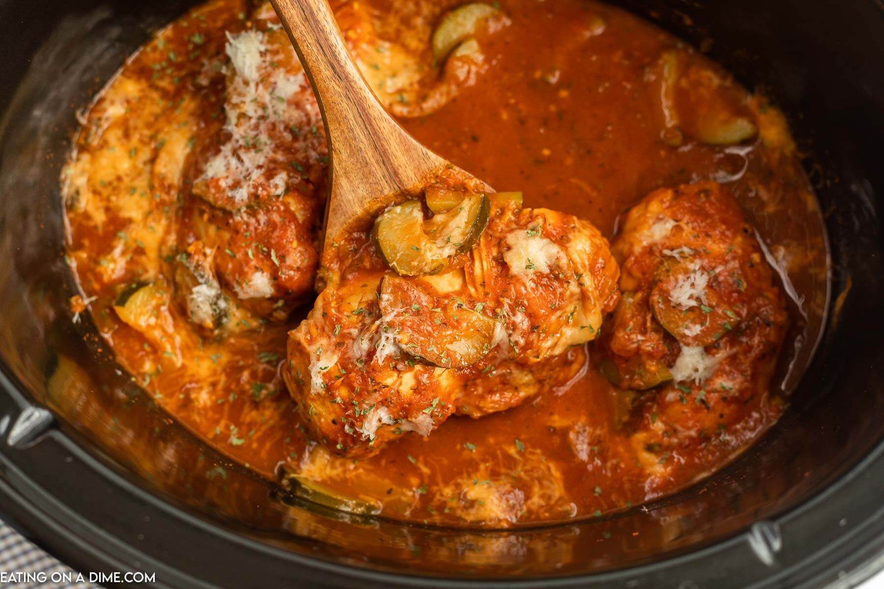 Chicken and Zucchini in a slow cooker with a wooden spoon