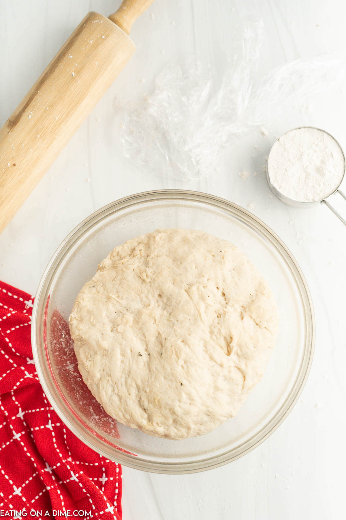 Dough ball in a bowl with a rolling pin on the side